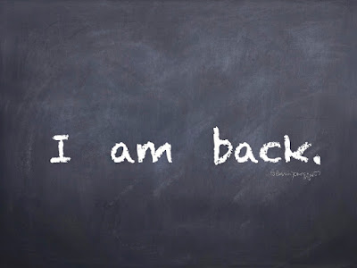 This is an image of a chalk board with the words I am back written on it.