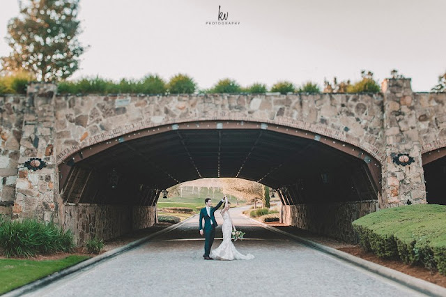 Bride and groom dancing under bella collina bridge