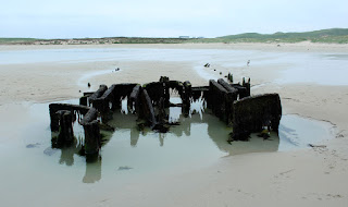 The shipwreck seems to be sinking into the sand