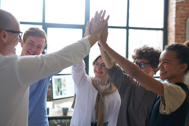 Young womens, mens & Old men in a professional setting, confidently networking with each others. Doing hi-five together.