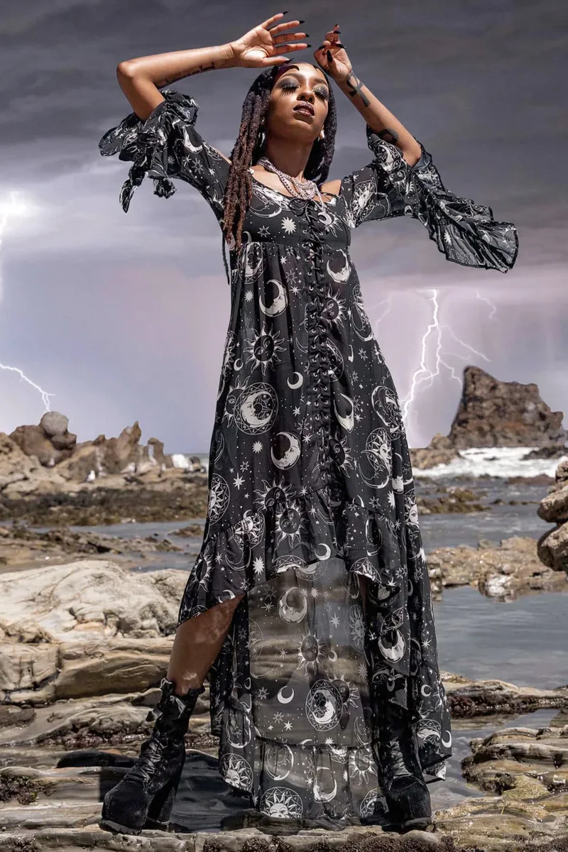 beautiful young woman in a celestial witchy outfit is posing for the camera