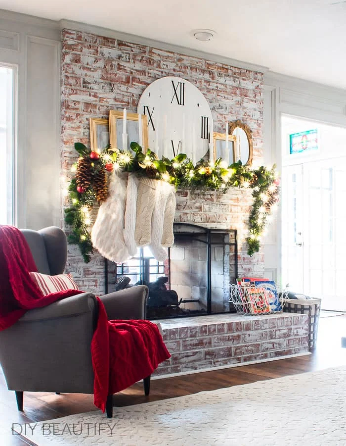 Christmas fireplace with full garland, candles and mirrors