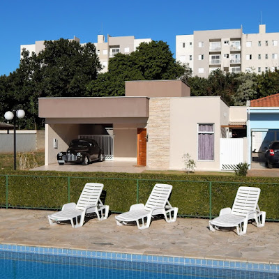 A fachada da casa, voltada para a face oeste, onde o sol se põe, possui a janela dimensionada para mesclar a fonte de luz natural da sala, sem levar excesso de calor para o interior da edificação, no período da tarde.