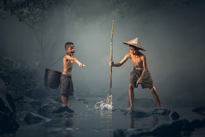 two kids standing in or over some water