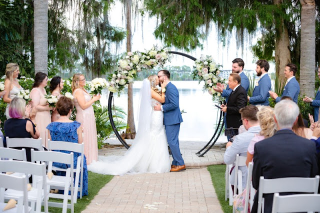 bride and groom with circular arch and floral at paradise cove