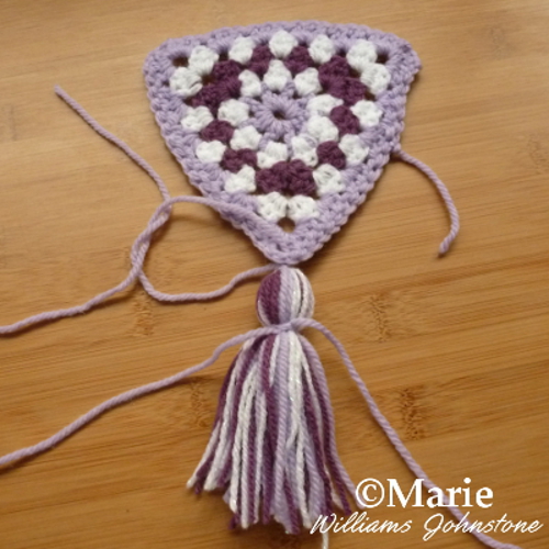 Adding a tassel to a crocheted banner section for a garland