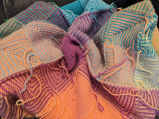 Back of Hue Shift Afghan with ends sticking out, some having been woven in and waiting for their snipping, and some waiting for their weaving in opportunity.