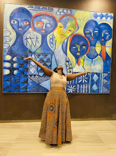 Photo of Sikiliza posing against art backdrop