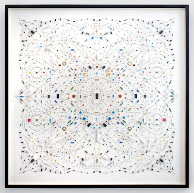 Technological Mandala, the work by Leonardo Ulian. A complex symetry pattern made from electronic components and microchips. It shows contrast between hard cold tech objects in a warm spiritual Hinduism symbol.