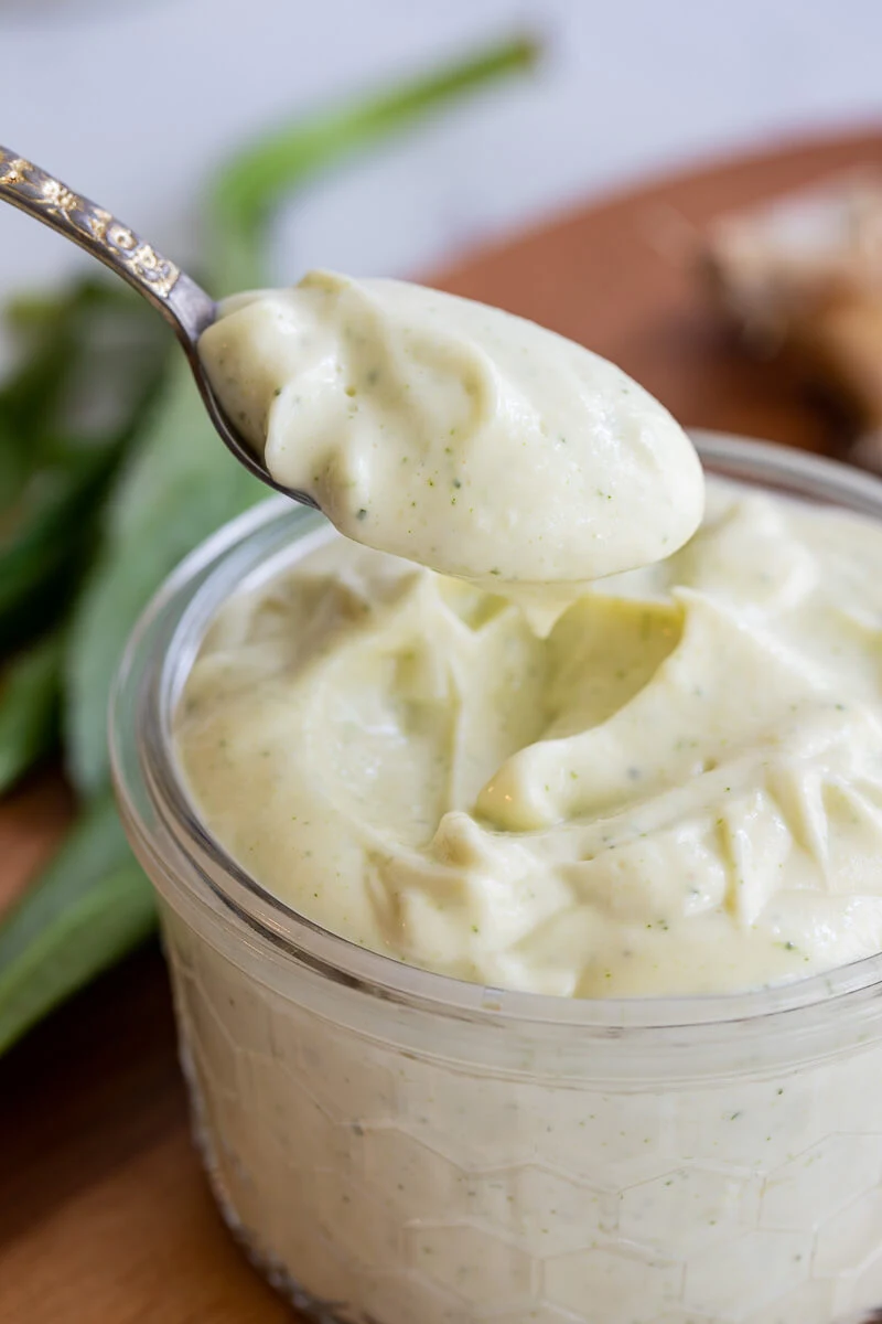 A spoonful of garlic sauce being pulled from the jar.