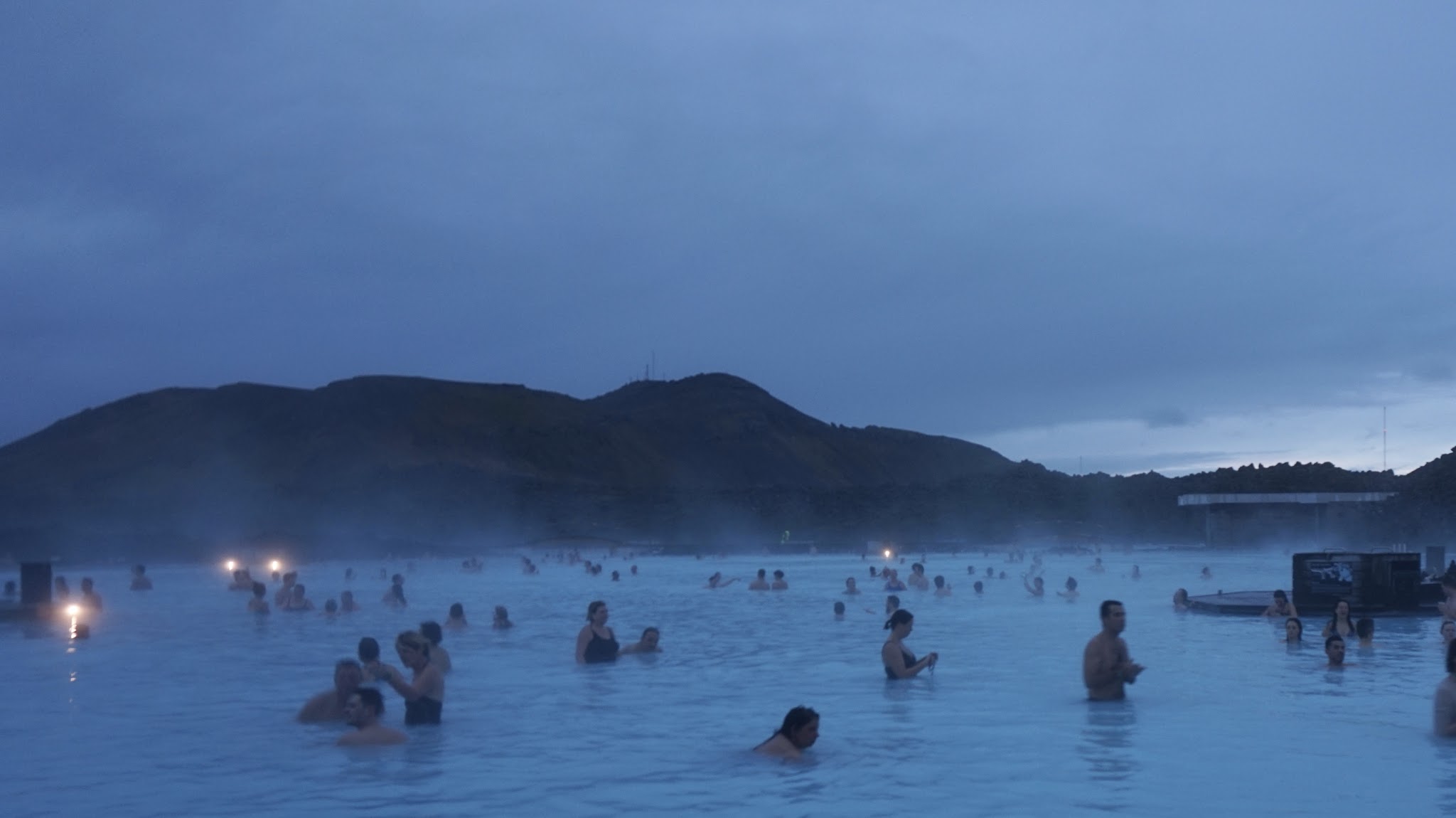 evening, lots of people swimming, steam rising off the water into the atmosphere