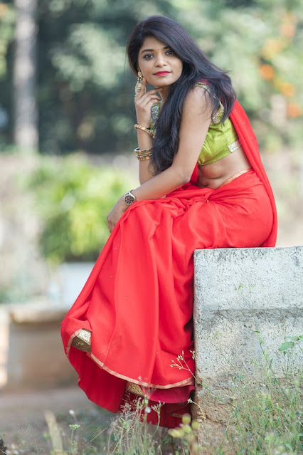 A woman in red saree and green blouse