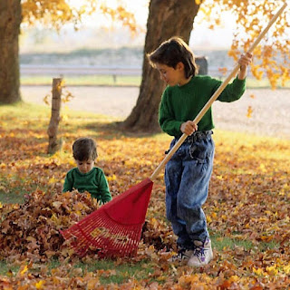 Imagen de unos niños barriendo hojas en Otoño
