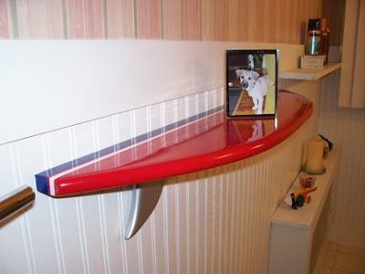 red surfboard wall shelf with framed photo of dog on it