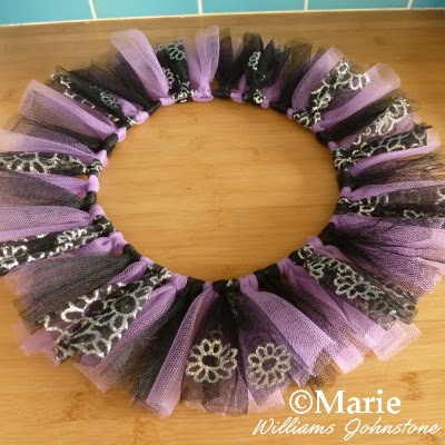 Black, purple and silver glitter fabrics tied around the wire base