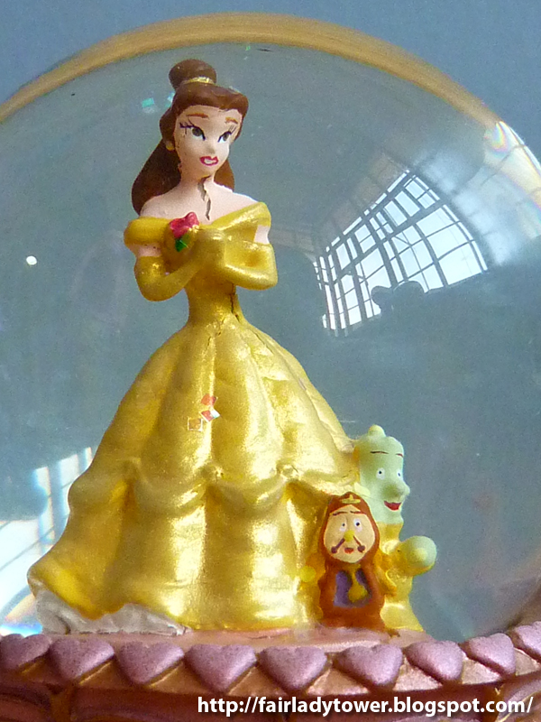 This Beauty and the Beast snowglobe features a handpainted Belle standing on