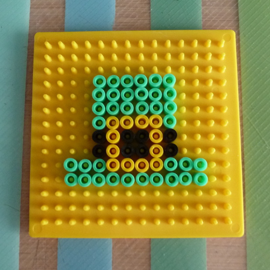 Yellow pegboard with green Leprechaun hat bead pattern