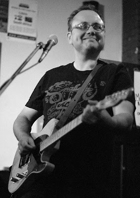 Black and white image of guitarist smiling, Toronto portrait photographer Robert Rafton