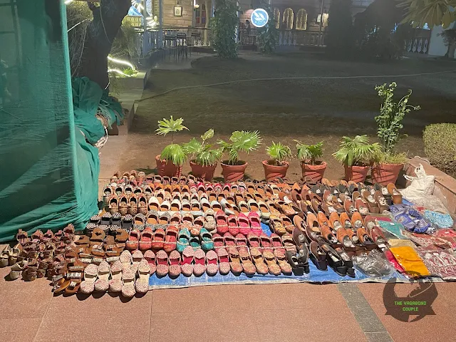 Jodhpuri slippers and dupattas for sale by a vendor inside the hotel lawn