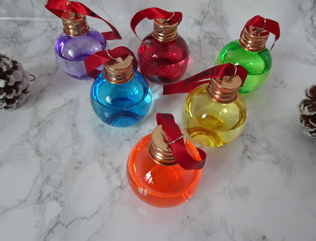 six small clear baubles filled with gin 