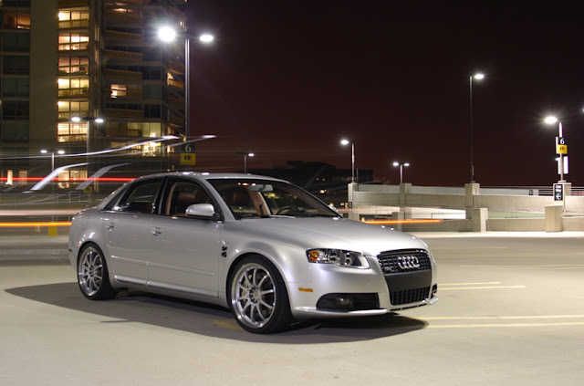 Silver 2013 Audi A4 2.0T quattro on rooftop garage at night with buildings in background