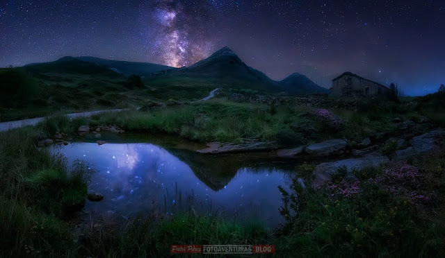 Reflejo de la Vía Láctea en charco con paisaje pasiego, cabaña y dos picos bajo el cielo estrellado