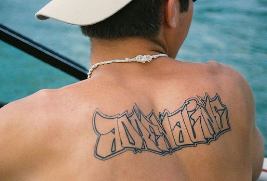 David Beckham shirtless showing off his back tattoos. Read More: