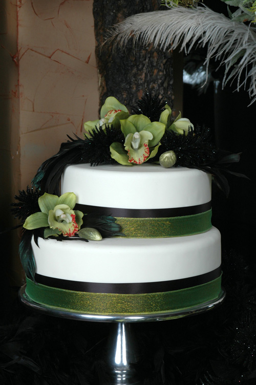 Simple and elegant two tier round cake decorated with black and green ribbon