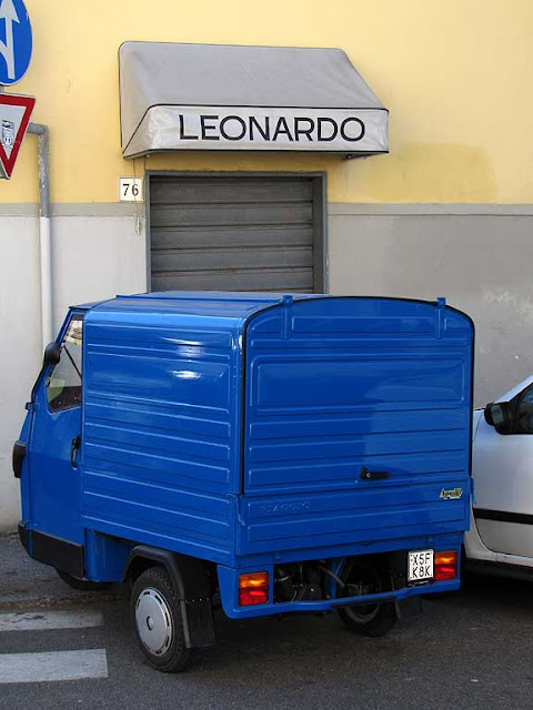 Insegna con scritto Leonardo, Ape Piaggio blu, via dell'Origine, Livorno