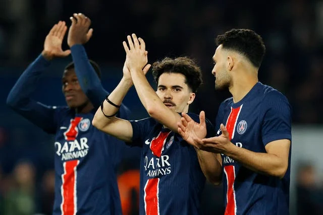 Três jogadores do PSG aplaudindo: Ousmane Dembélé à esquerda, Vitinha no centro e Gonçalo Ramos à direita, olhando para Vitinha enquanto aplaude.