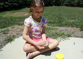 Tessa rubbed sandpaper on a mock rock.