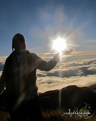 A Man holding the sun at Mt. Pulag Peak in Benguet