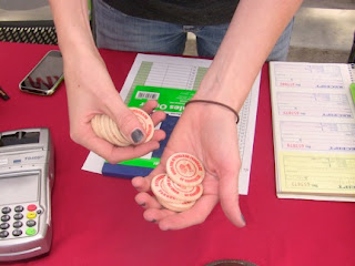 Manager at the campus farmer's market hands out tokens in exchange for food stamps to be used at the market.