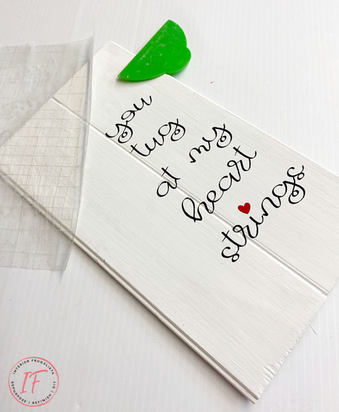 A quick and easy DIY scrap wood sign idea for valentine's day with an adorable heartstring quote that costs next to nothing to make.