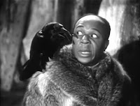 Eddie 'Rochester' Anderson is wearing a big fur coat and looking in surprise at a raven that has landed on his shoulder