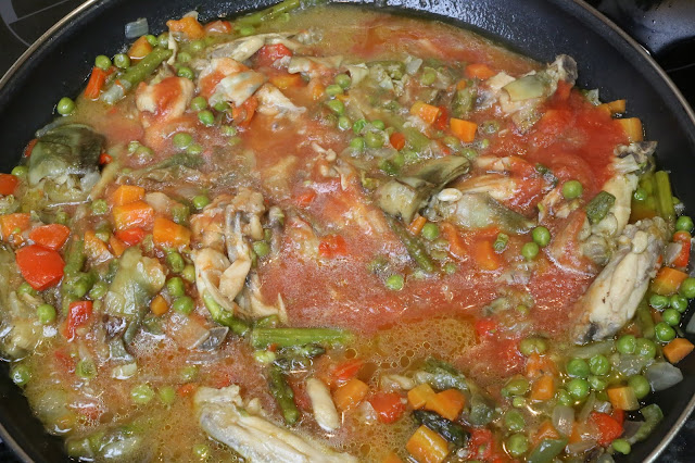 Arroz con pollo y verduras cocinandose