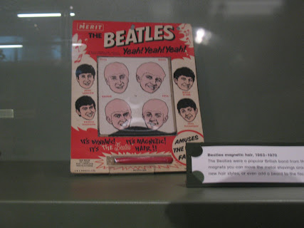 Photo of a game where you use a magnet to place magnetic filings in the correct hairdo for each Beatle.