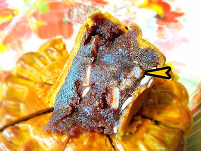 A wedge of red bean mooncake with tangerine peel.