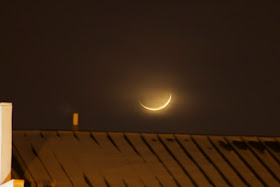 crescent moon over building roof
