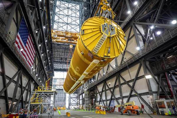 Inside the VAB, the SLS core stage booster for Artemis 1 is lifted into the air by two large cranes at NASA's Kennedy Space Center in Florida...on June 10, 2021.