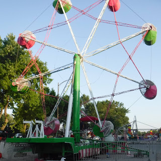 a colorful ferris wheel spins at the North Iowa Fair in Mason City, IA