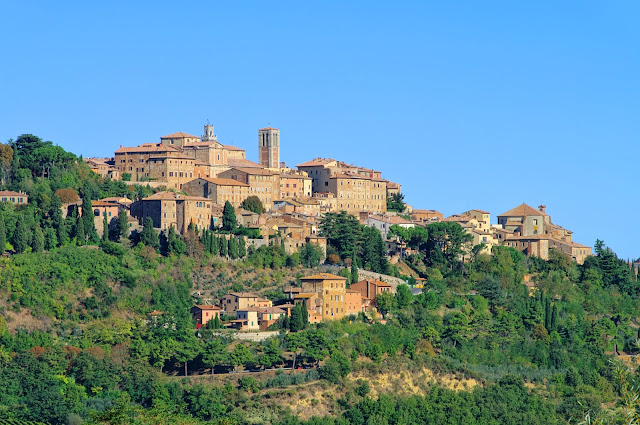 foto de Montepulciano no topo da colina mostrando as encostas plantadas com árvores