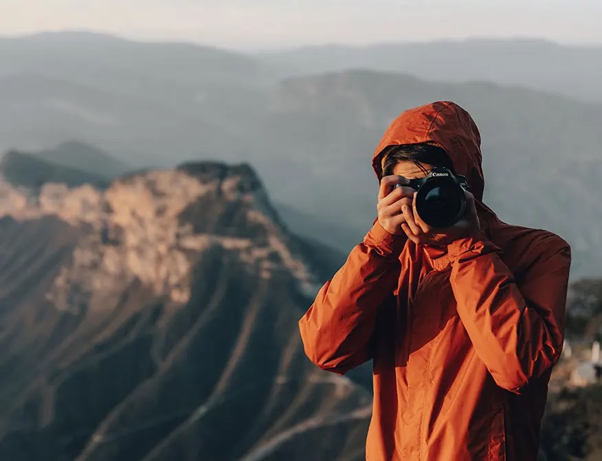 persona-sosteniendo-camara-fotografica-en-la-montaña