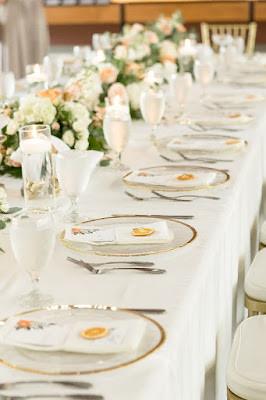 gold rimmed chargers with white napkin and menu fold with orange slices placed on top