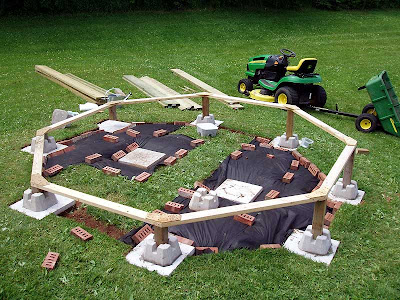 Hubby is starting to cover the grass with landscape cloth. The bricks are there just to hold the cloth in place.