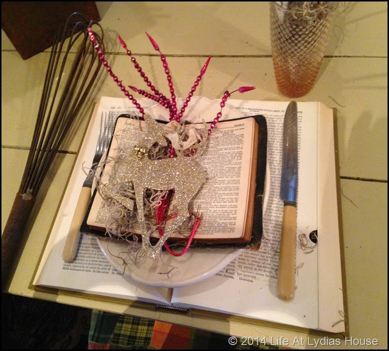 Round top table with books, Bibles, ornaments and whisks close up via Life At Lydias House