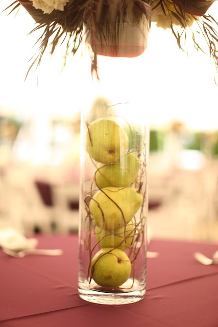 The floral centerpieces were placed atop these tall glass cylinder vases to