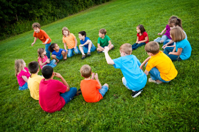 NAMC montessori advantage what is redshirting children playing outdoors in circle