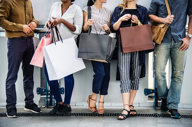 Five people carrying shopping bags