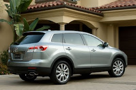 Rear 3/4 view of silver 2011 Mazda CX-9 in front of home